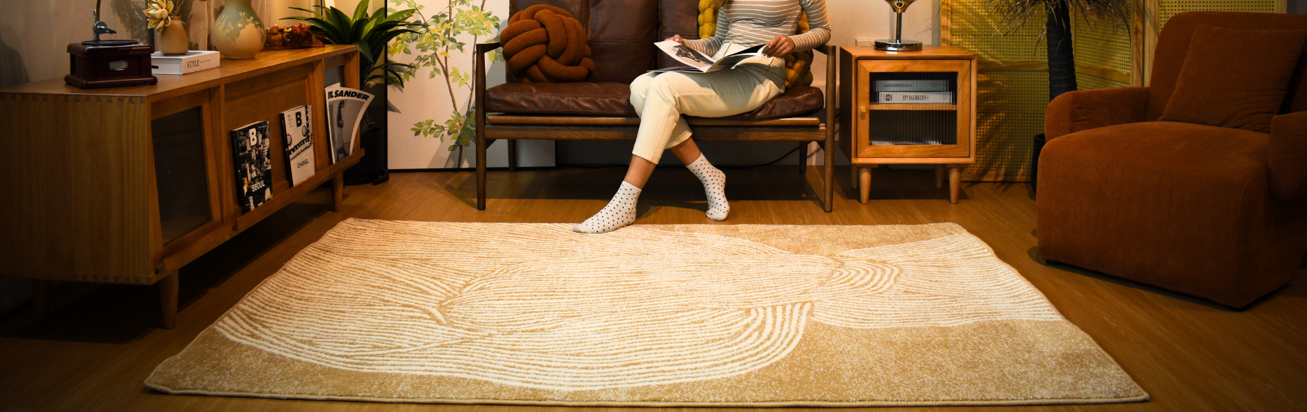 Lady reading a book with her legs on a beautiful scandinavian style carpet.