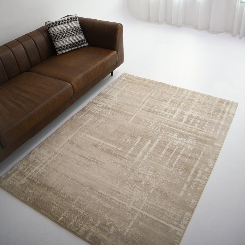 A beige carpet with subtle textured patterns is placed next to a sofa. The modern design adds elegance to the living space.