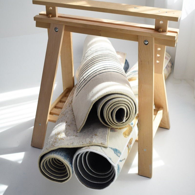 A collection of rolled-up carpets displaying different designs, including stripes and floral patterns, stored on a rack.