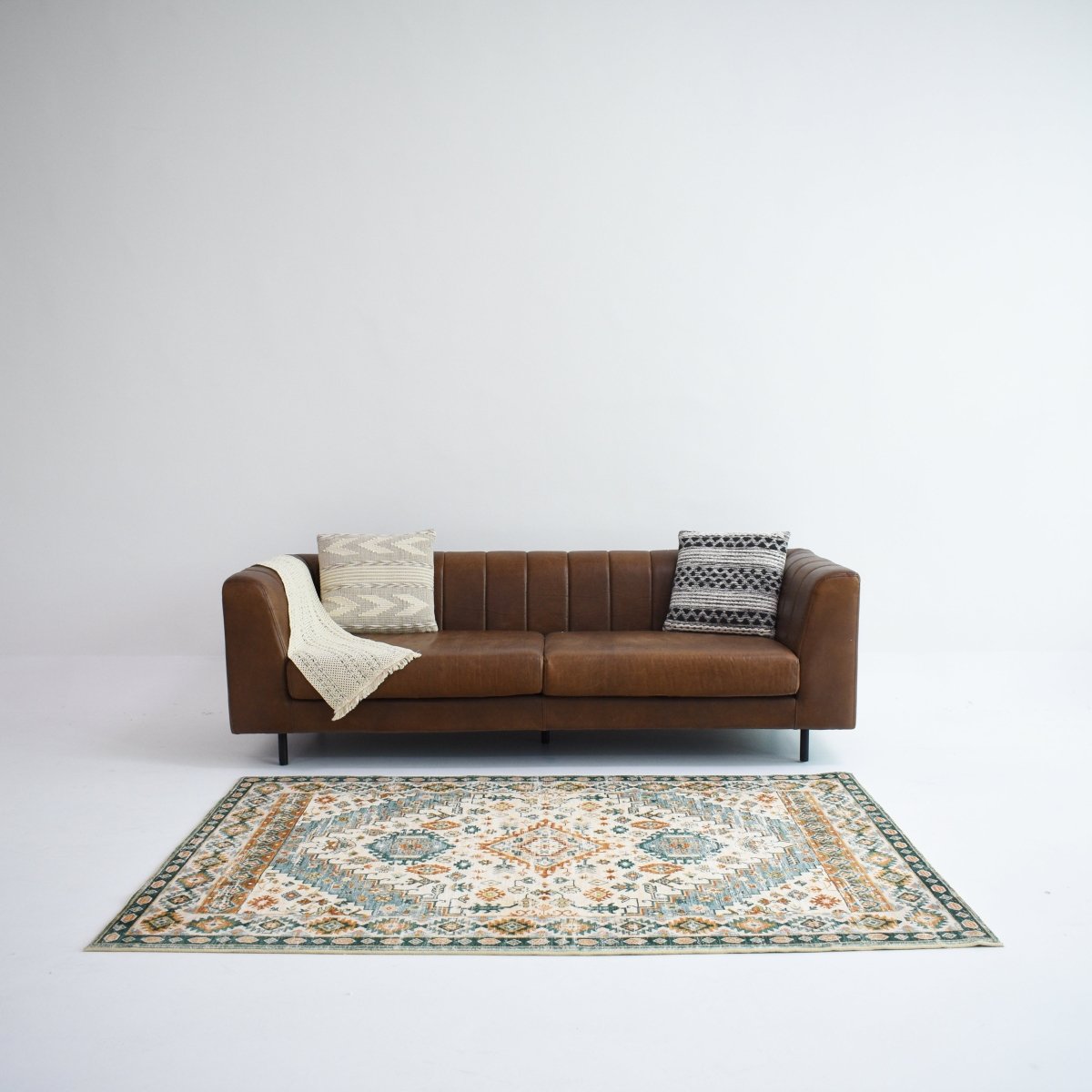 A beautifully detailed rug featuring a vibrant combination of teal, rust, and cream, complementing any living space.