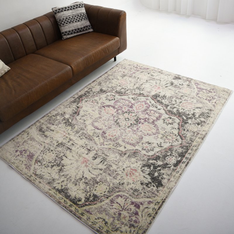 A vintage-style rug with intricate floral patterns in purple and gray tones, adding elegance and charm to the living space.