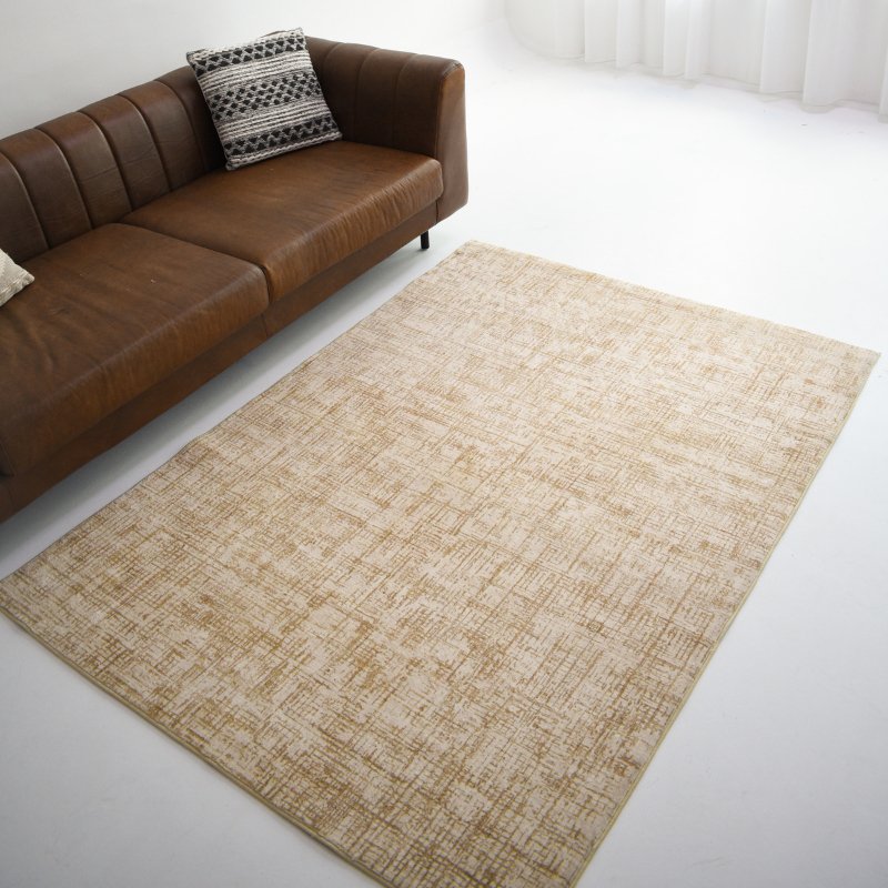 A beige carpet with a crosshatch design, placed next to a brown sofa, adding warmth and a modern touch to the living space.