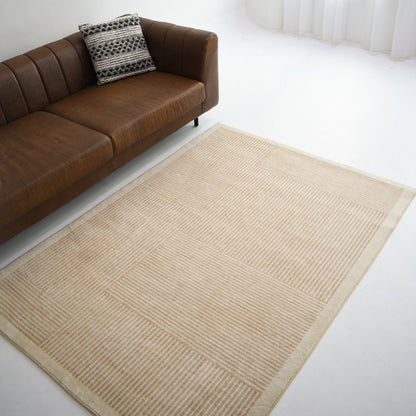 A beige carpet featuring a grid design with stripes and solid sections, adding a subtle yet modern touch to any room decor.